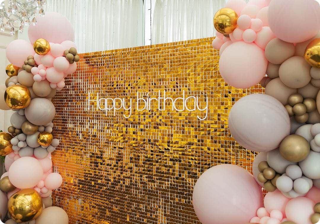Balloon décor backdrop in Bellevue with gold shimmer wall and pastel balloon garland for a birthday event